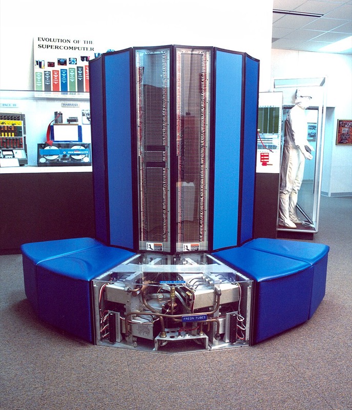 A Cray X-MP supercomputer: a C-shaped tower of blue panels with a bench seat around its base.