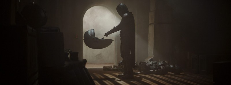 The Mandalorian in armor in a desert landscape.