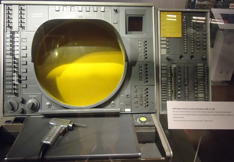 A SAGE operator console with its round situation display and a light gun on a cable.
