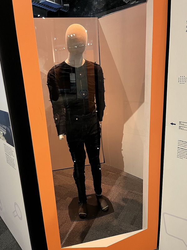 A performer&rsquo;s motion-capture suit covered in small reflective markers, on museum display.